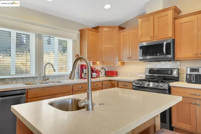a kitchen with stainless steel appliances a refrigerator sink and microwave