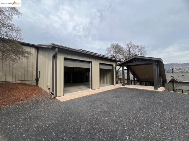 a view of a house with a barbeque and wooden fence