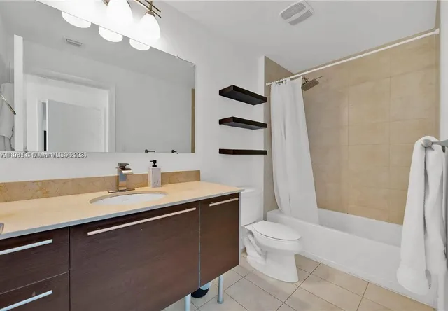 a bathroom with a sink a toilet a mirror a vanity and shower