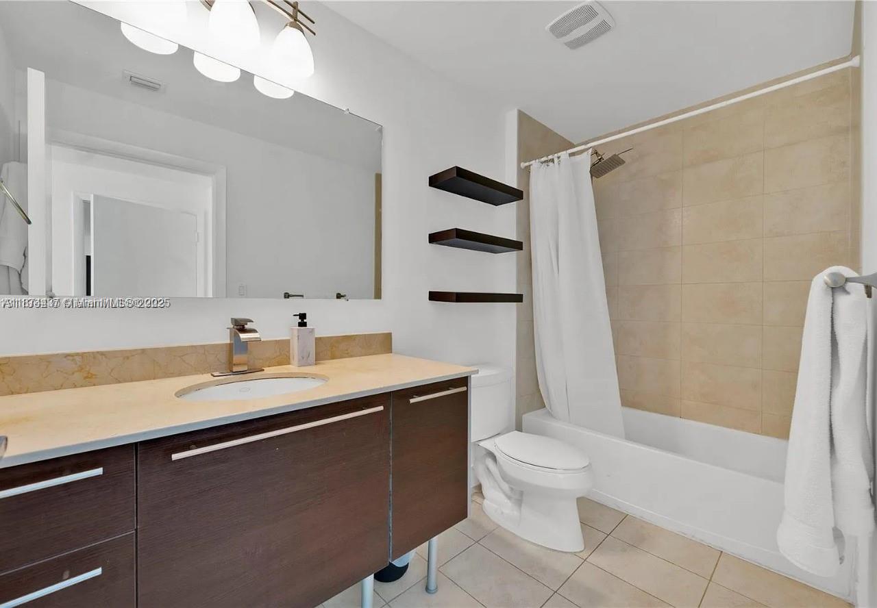 1900 North Bayshore Drive, Unit 3507 Miami, FL 33132 - Photo 7 of 22 a bathroom with a sink a toilet a mirror a vanity and shower