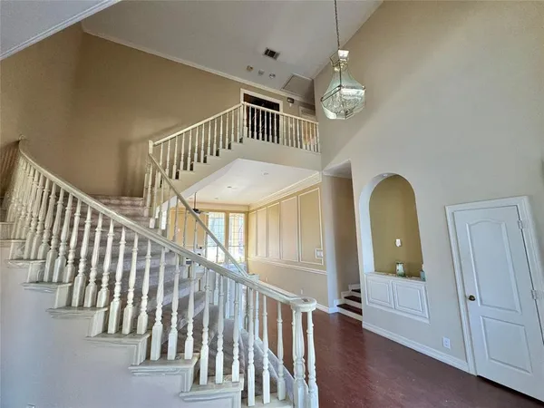 a view of staircase with railing and pendant lights