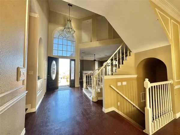 a view of a hallway with wooden floor and staircase