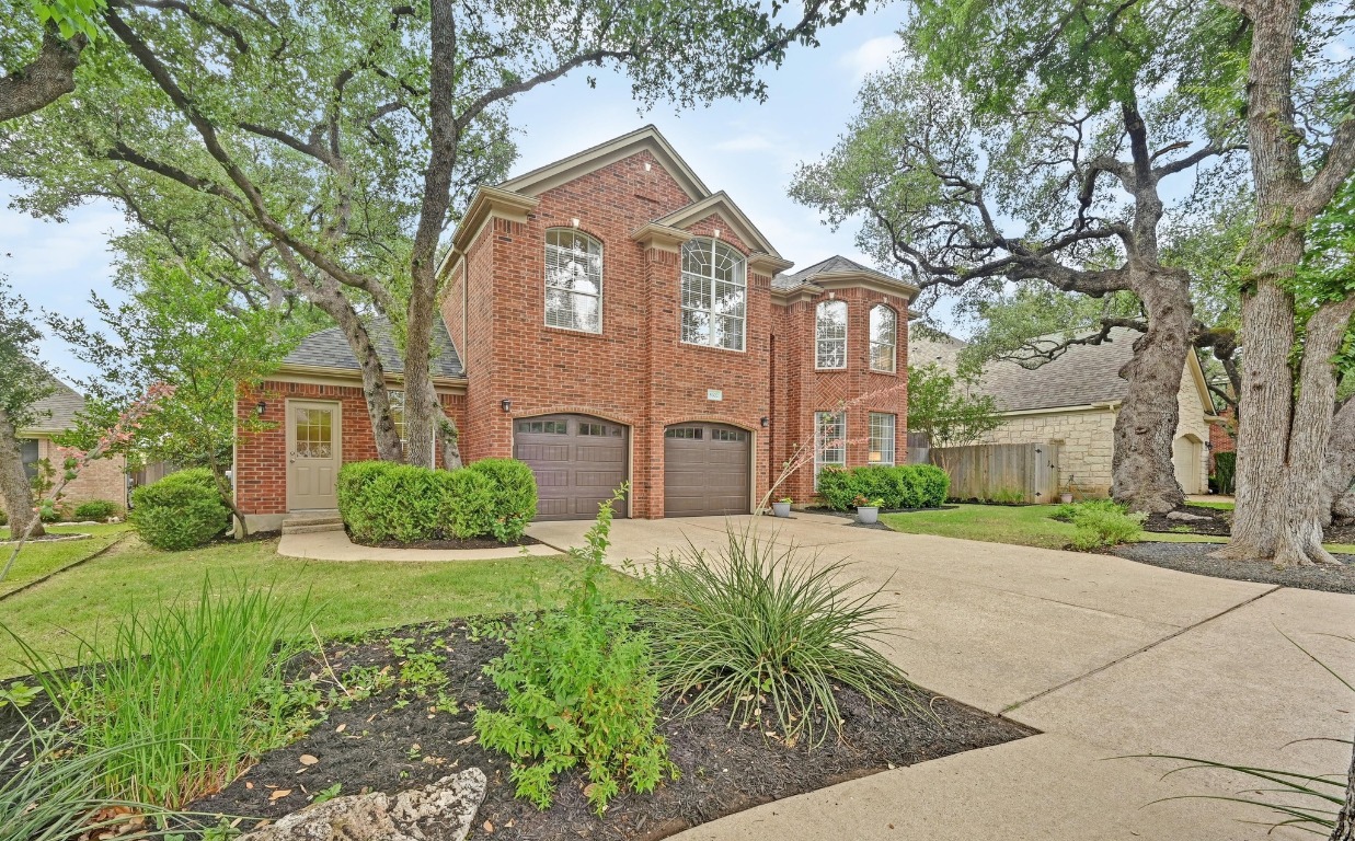 a front view of a house with a yard and potted plants