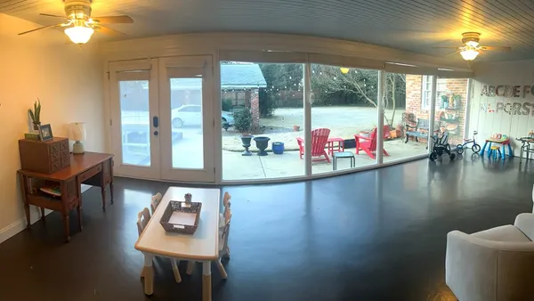 a living room with furniture and floor to ceiling windows