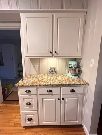 a kitchen with granite countertop a sink and cabinets