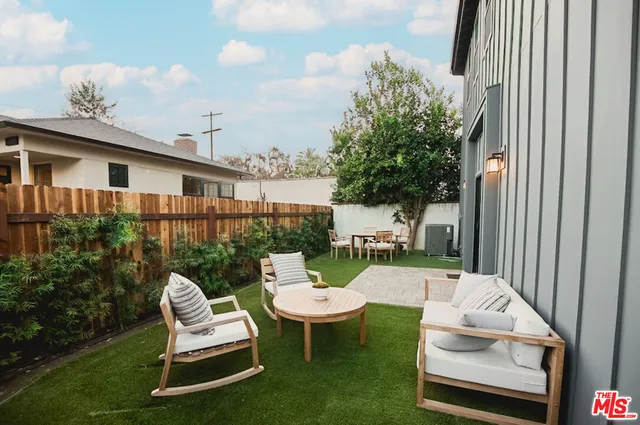 a view of a chair and table in backyard of the house
