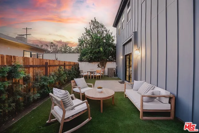 a view of a patio with couches table and chairs and potted plants