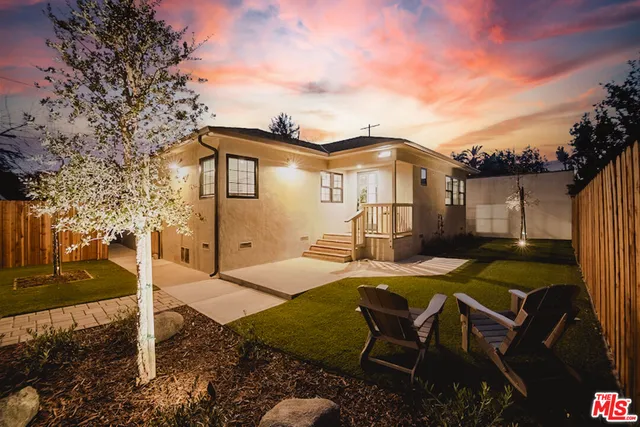 a view of a house with backyard and sitting area