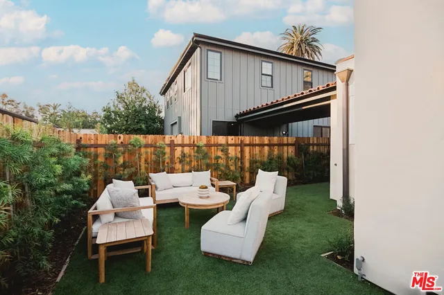 a view of a chair and tables in the back yard of the house