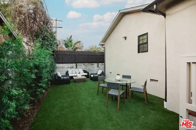 a backyard of a house with table and chairs