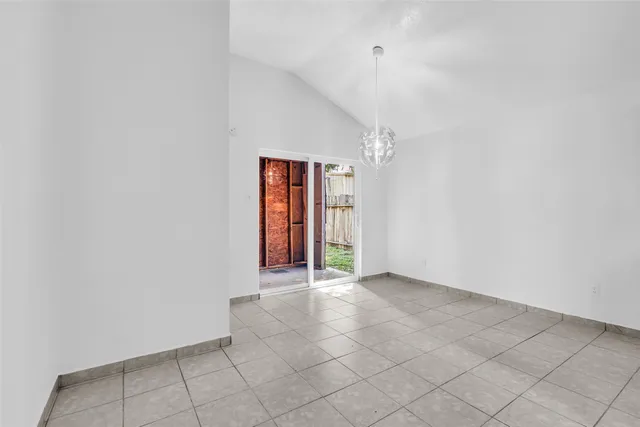 an empty room with sliding door and chandelier fan