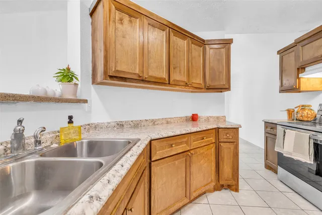 a kitchen with stainless steel appliances granite countertop a sink a stove and cabinets