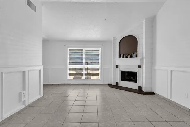 a view of an empty room with a fireplace and a window