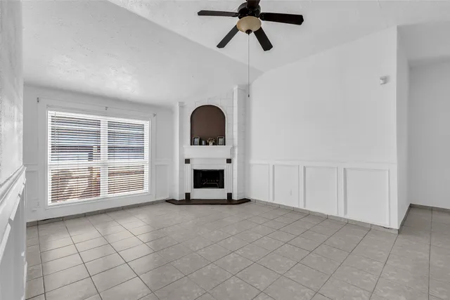 a view of an empty room with a fireplace and a window