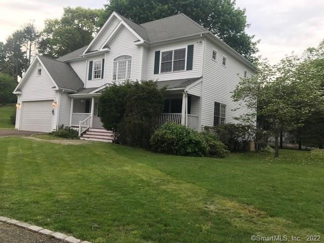 a view of a white house next to a yard with big trees
