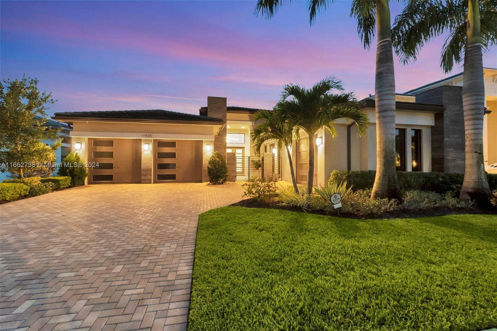 a front view of a house with a yard and palm trees
