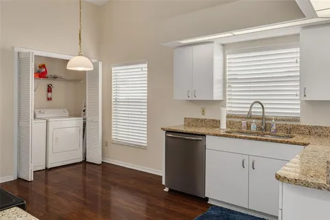 a kitchen with a sink cabinets and wooden floor