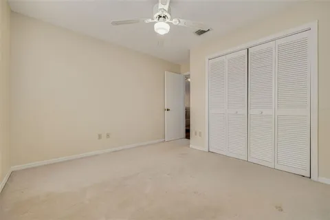 an empty room with a ceiling fan and closet area