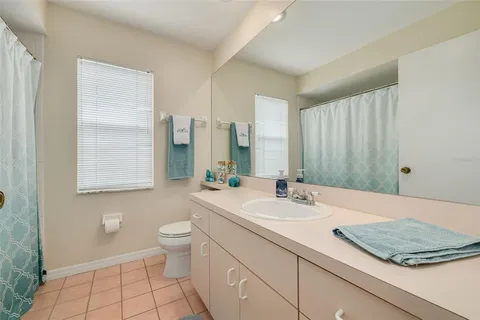 a bathroom with a granite countertop sink a toilet a mirror and shower