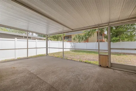 a view of an empty room with a floor to ceiling window and a yard