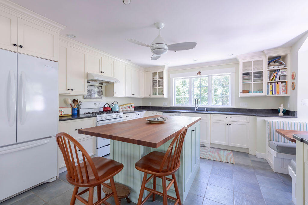 30 Amy's Way Wellfleet, MA 02667 - Photo 23 of 64 a kitchen with stainless steel appliances granite countertop a stove a sink dishwasher a stove a refrigerator with a dining table and chairs