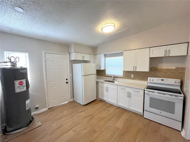 a kitchen with refrigerator and cabinets
