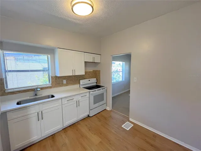 a kitchen with a sink cabinets and wooden floor