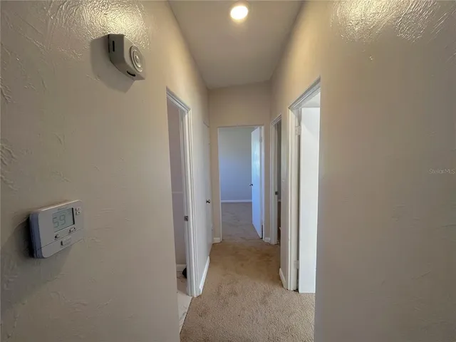 an empty room with windows and ceiling fan