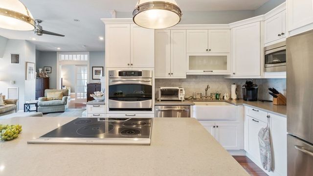 a kitchen with stainless steel appliances a stove a sink a microwave a refrigerator and cabinets