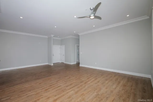 a view of an empty room with ceiling fan