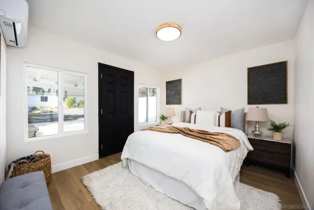 a bedroom with a bed and a flat tv screen on the dresser