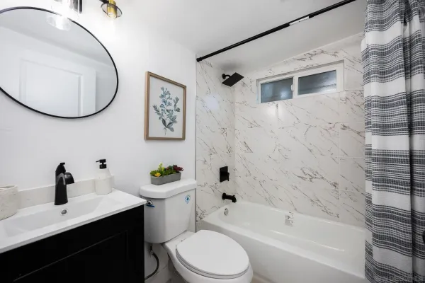 a white toilet sitting next to a bathroom sink and a tub