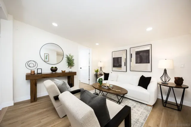 a living room with furniture a clock and a flat screen tv