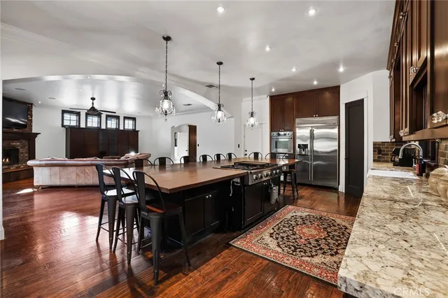 a large kitchen with lots of counter space a sink appliances and a wooden floor