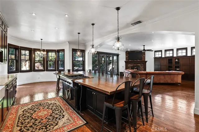 a kitchen with stainless steel appliances granite countertop a sink a stove and a wooden floors