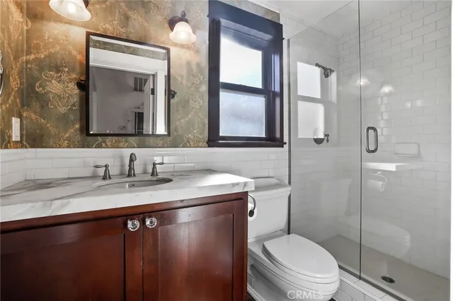a bathroom with a granite countertop sink a toilet and a mirror