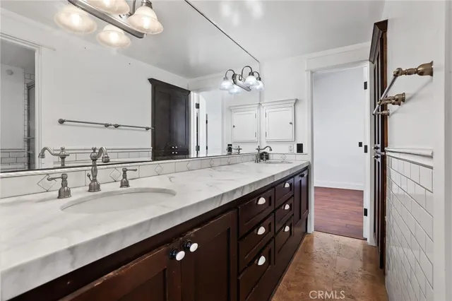 a bathroom with a double vanity sink a mirror and a shower