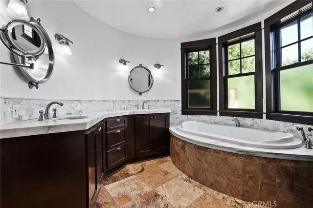 a spacious bathroom with a granite countertop sink mirror and window