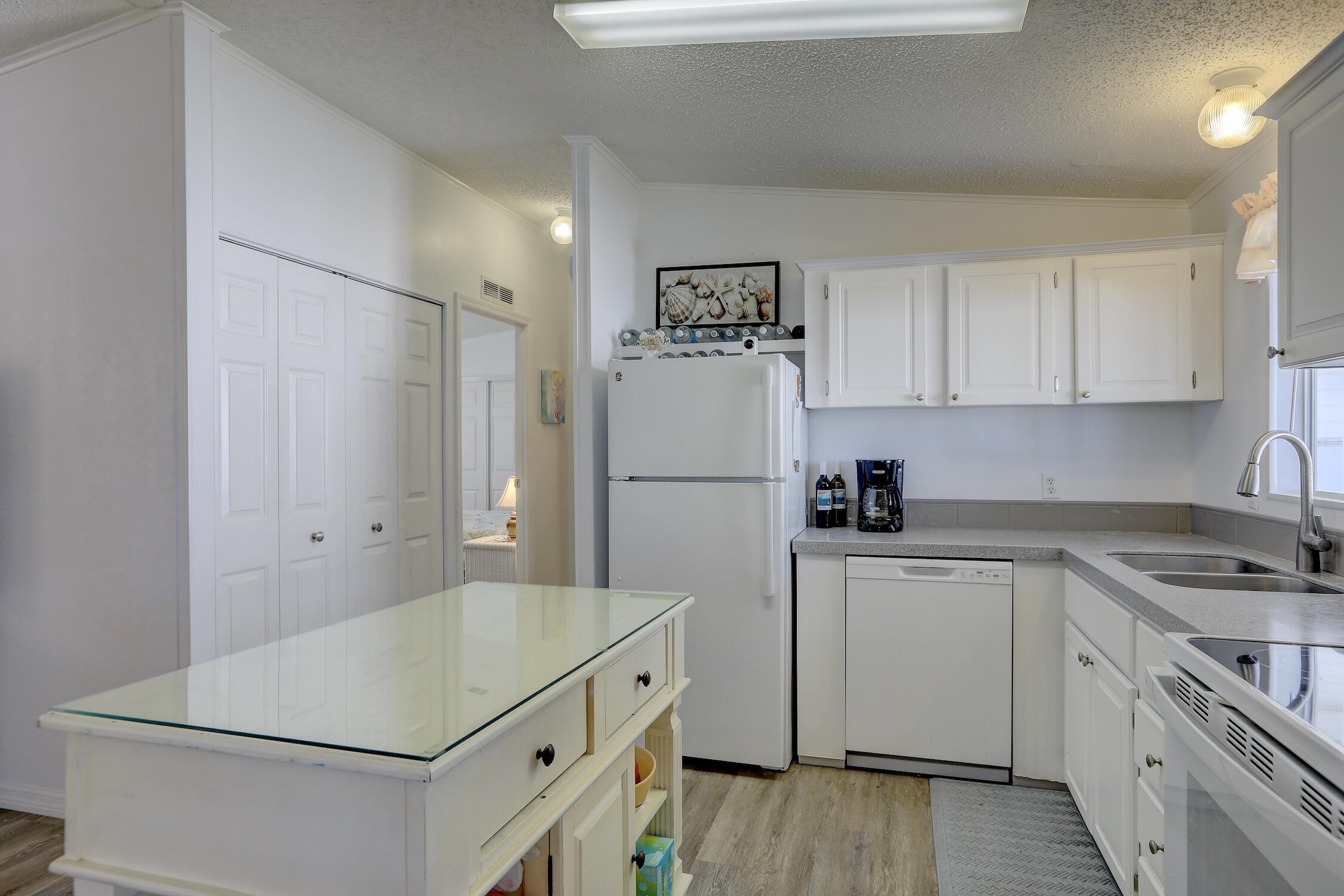 7576 Chasta Road Micco, FL 32976 - Photo 7 of 27 a kitchen with a refrigerator a sink and white cabinets