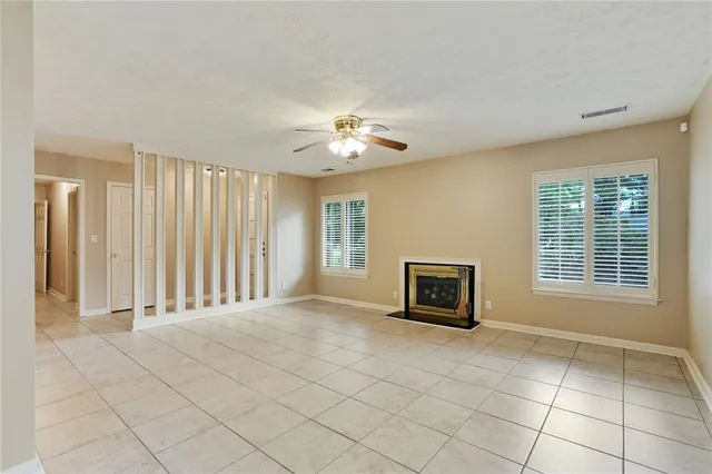 a view of an empty room with a fireplace and a window