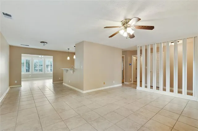 an empty room with fan and windows