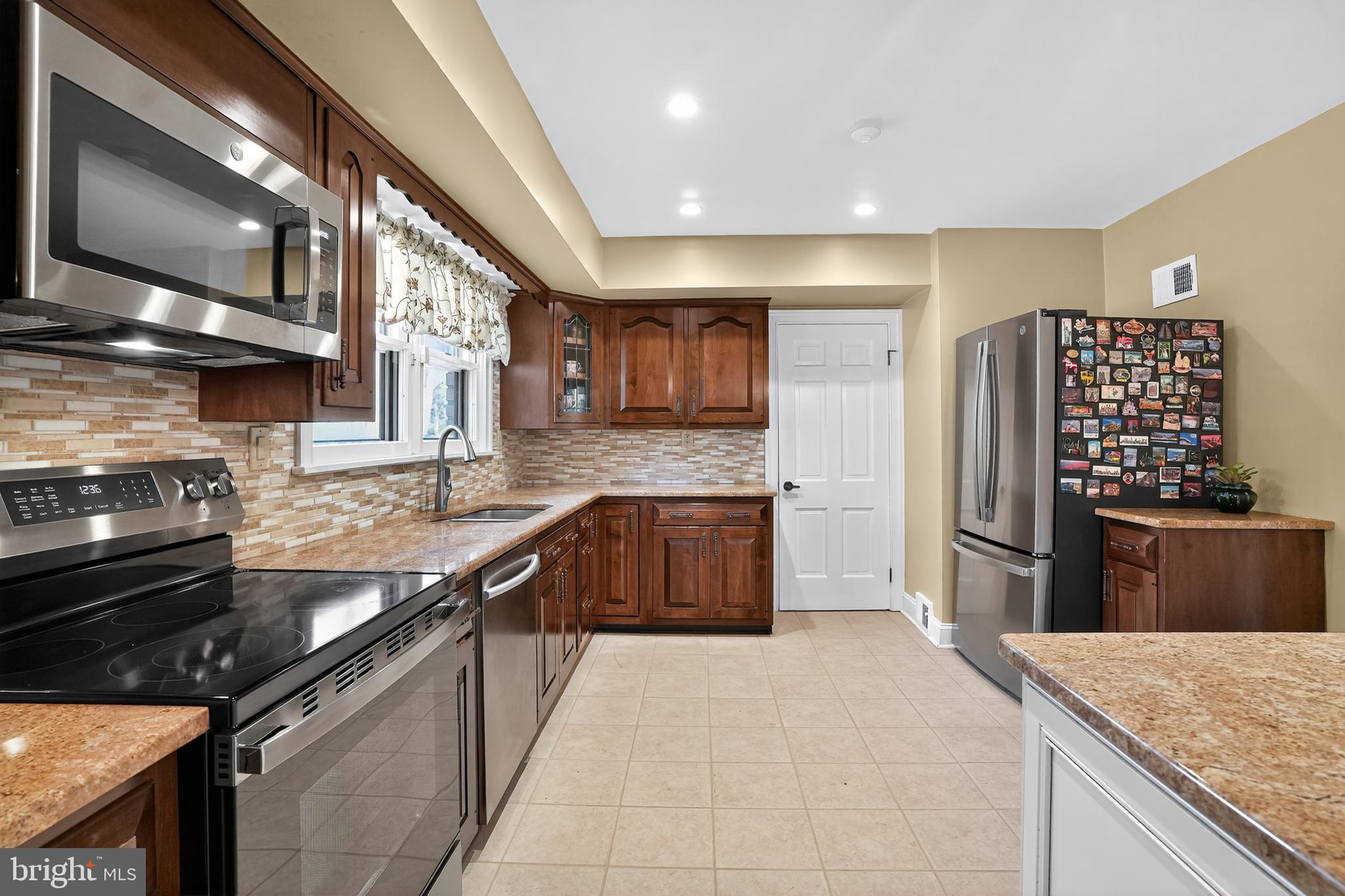 1013 Glen Road Wallingford, PA 19086 - Photo 27 of 45 a kitchen with stainless steel appliances granite countertop a sink stove and refrigerator