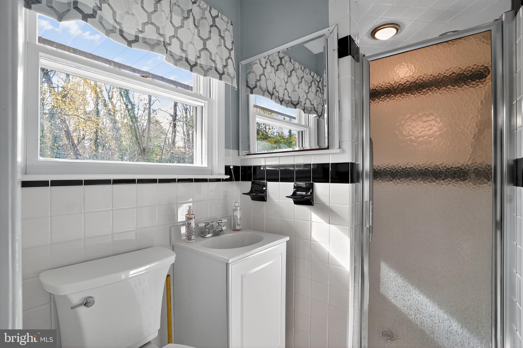 1013 Glen Road Wallingford, PA 19086 - Photo 40 of 45 a bathroom with a sink and a mirror next to a window