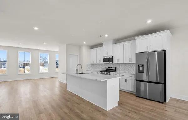 a kitchen with stainless steel appliances a refrigerator sink and microwave