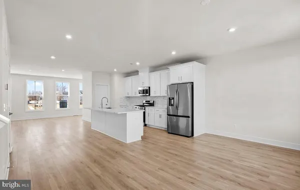 an open kitchen with white cabinets and stainless steel appliances
