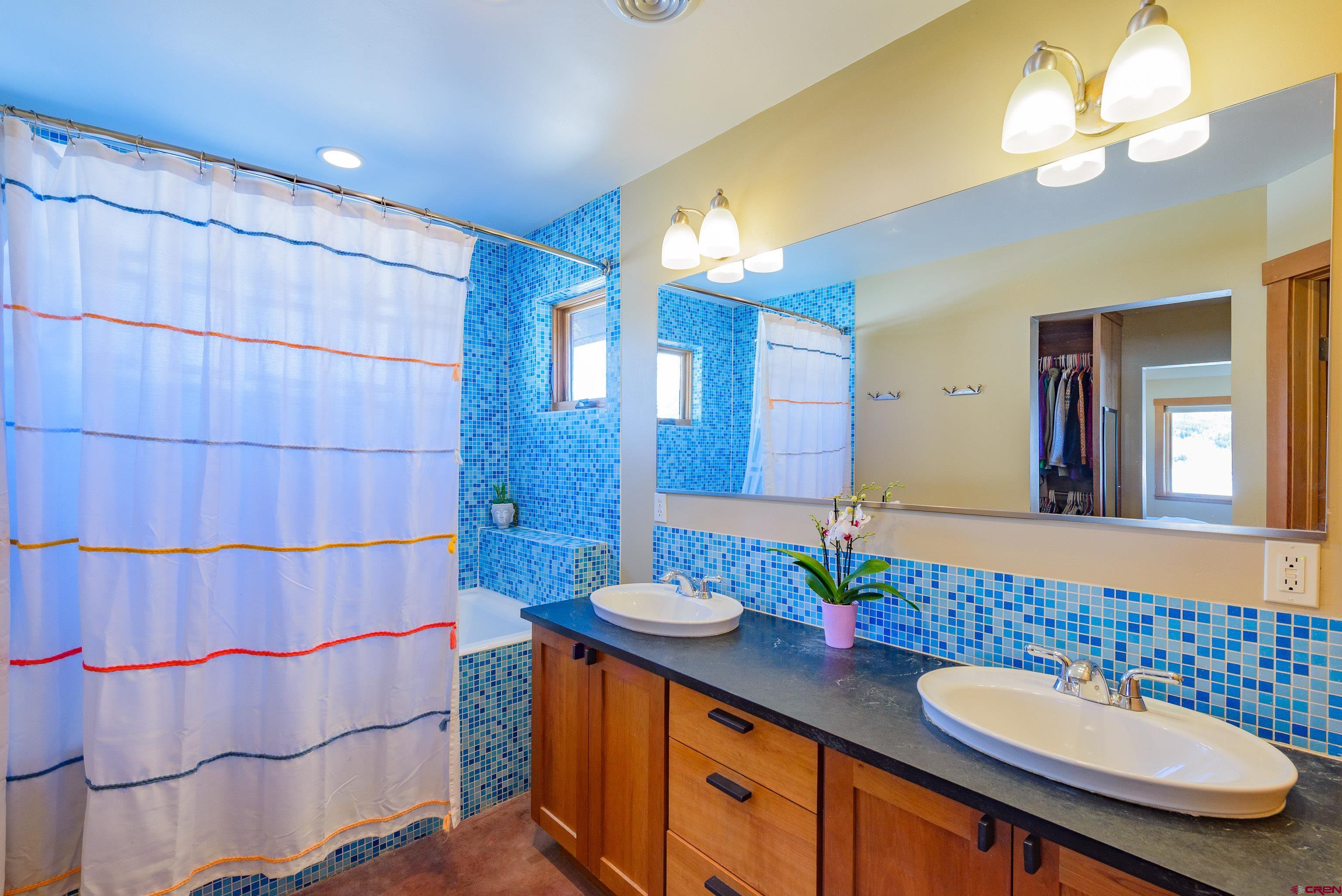 70 Bridle Spur Way Crested Butte, CO 81224 - Photo 15 of 42 a bathroom with a double vanity sink and a mirror