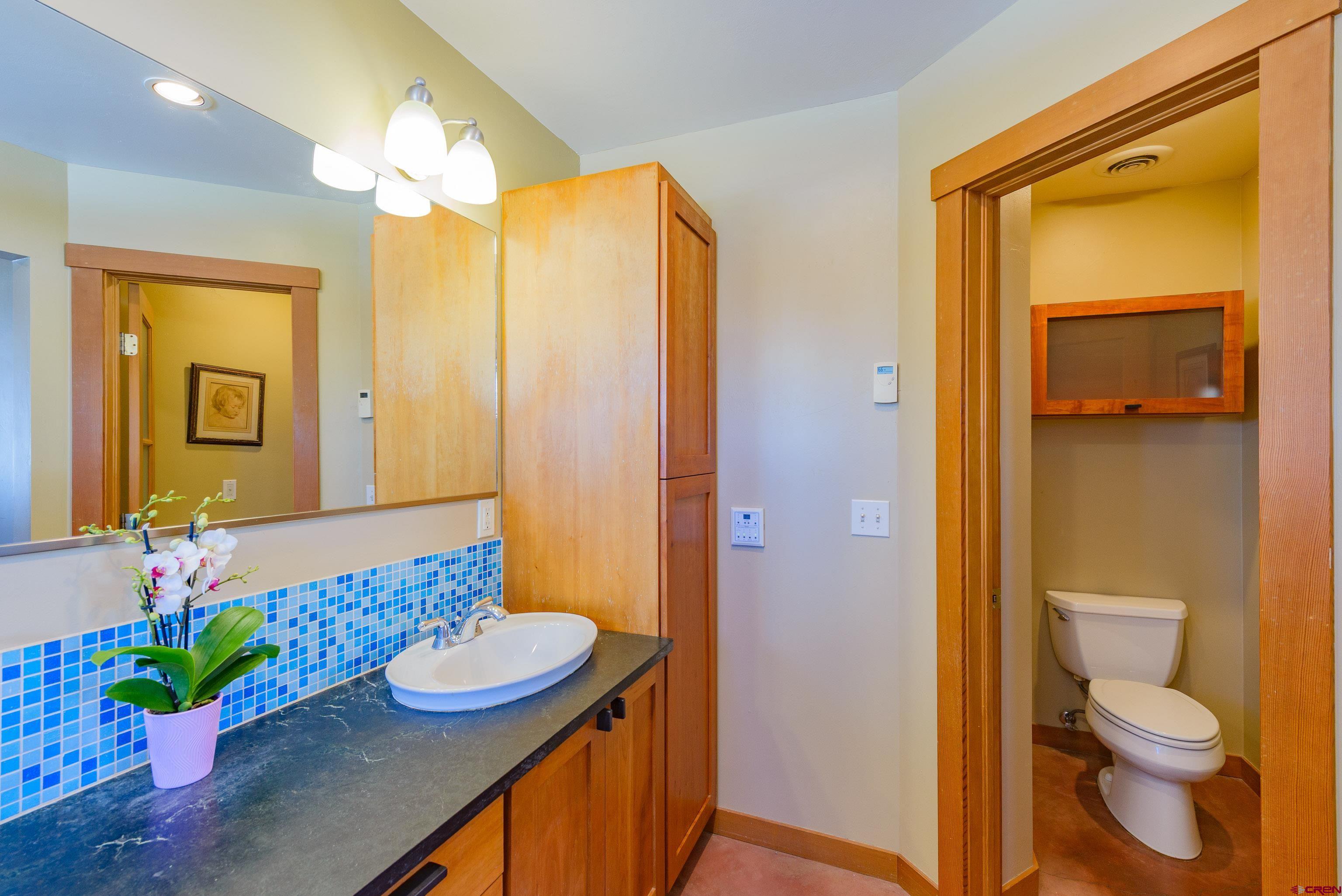 70 Bridle Spur Way Crested Butte, CO 81224 - Photo 16 of 42 a bathroom with a granite countertop sink and a mirror
