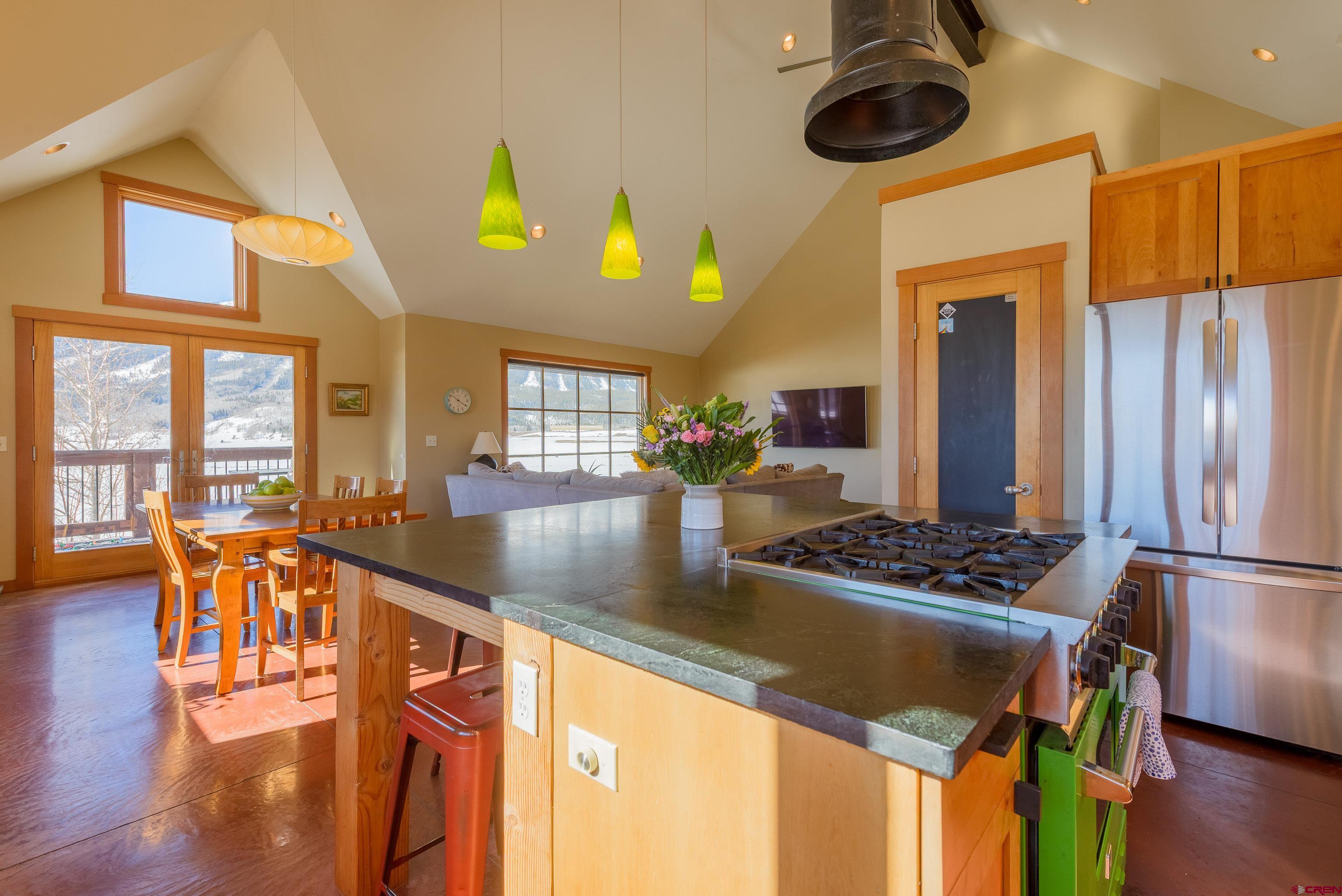 70 Bridle Spur Way Crested Butte, CO 81224 - Photo 6 of 42 a kitchen with stainless steel appliances granite countertop a stove and chairs with wooden floor