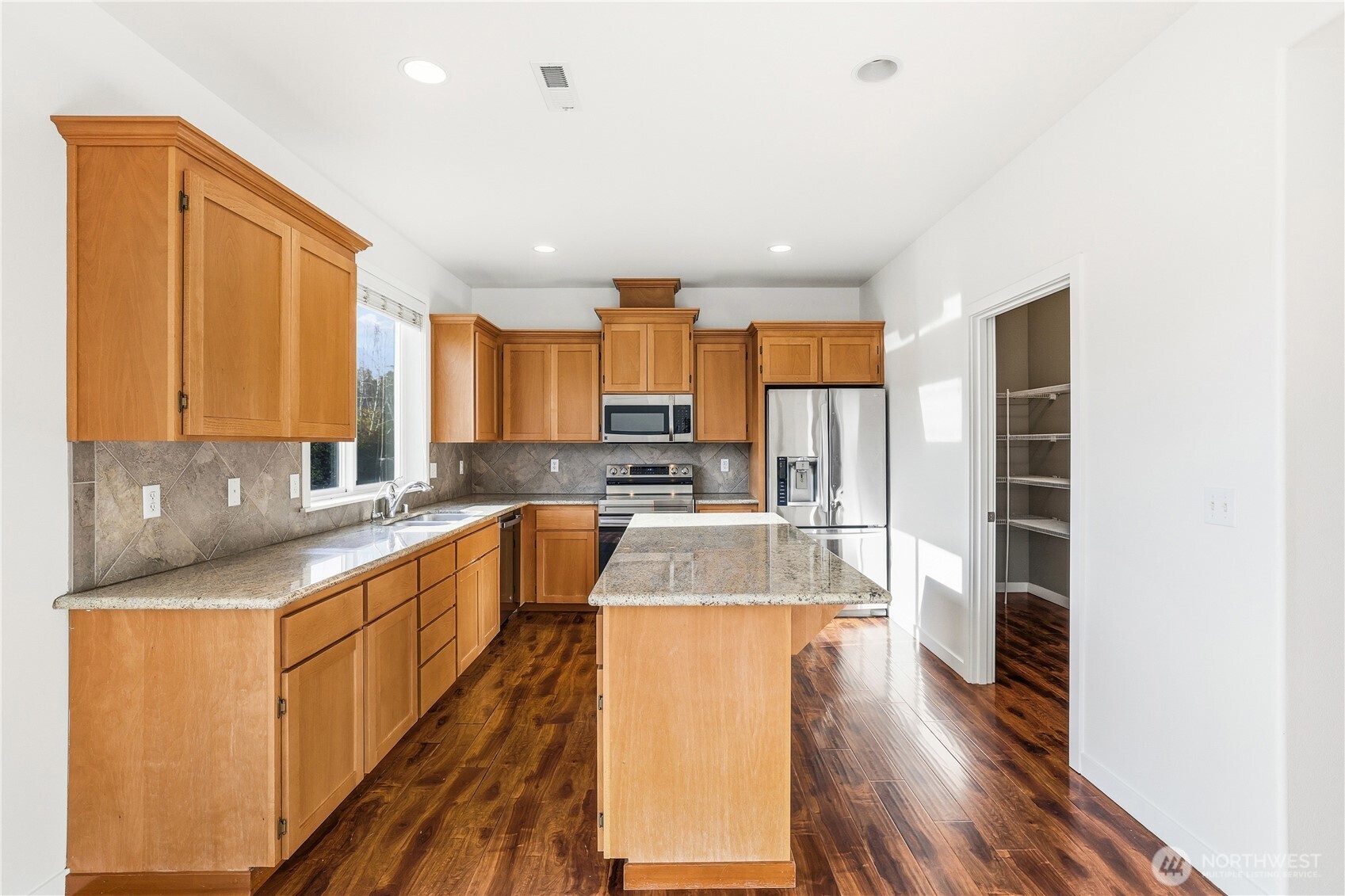 114 Ames Street Northeast Orting, WA 98360 - Photo 7 of 38 a large kitchen with a large window in it and stainless steel appliances