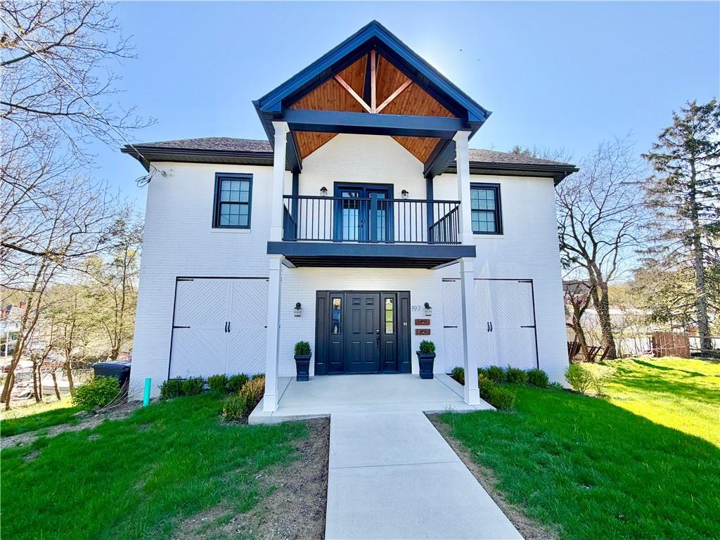 a front view of a house with yard and trees